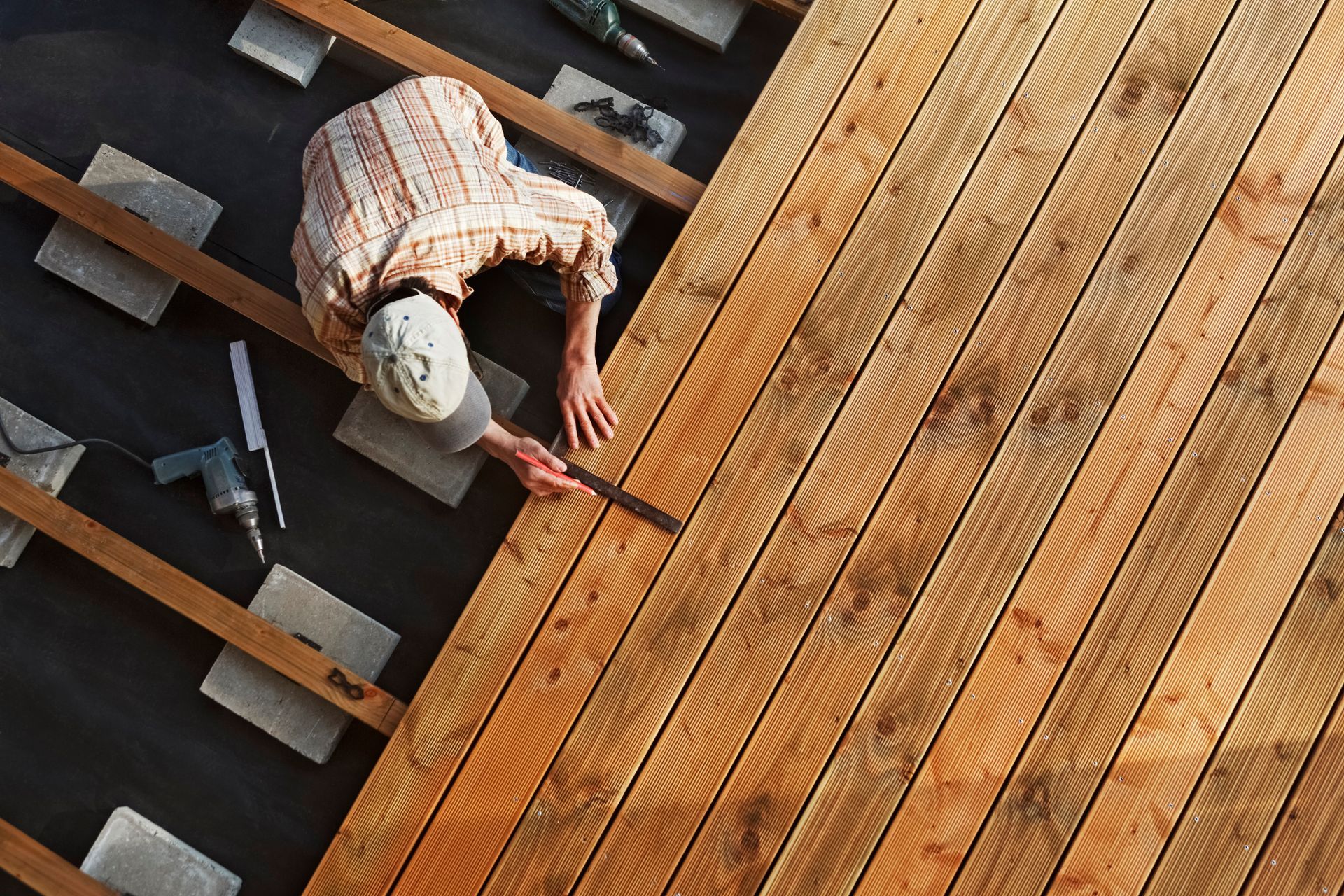 a man is working on a wooden deck .