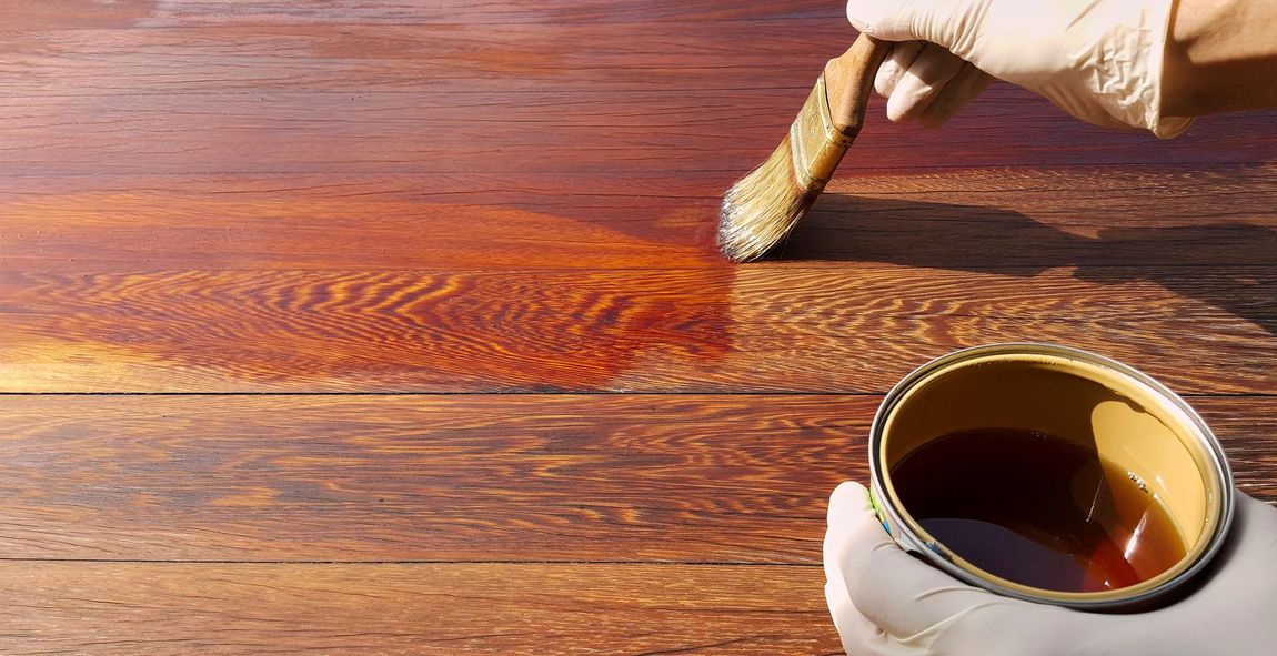 a person is painting a wooden surface with a brush .
