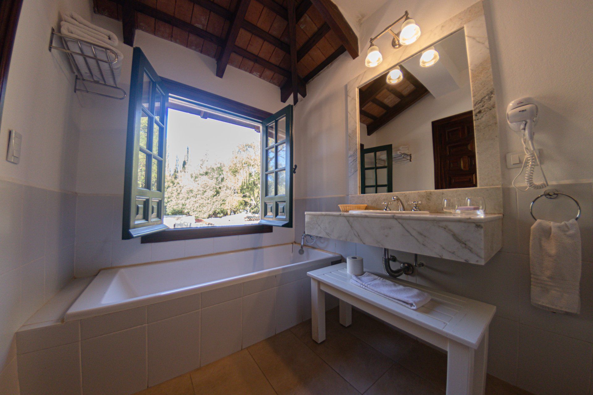 Un baño con lavabo, bañera, espejo y ventana.