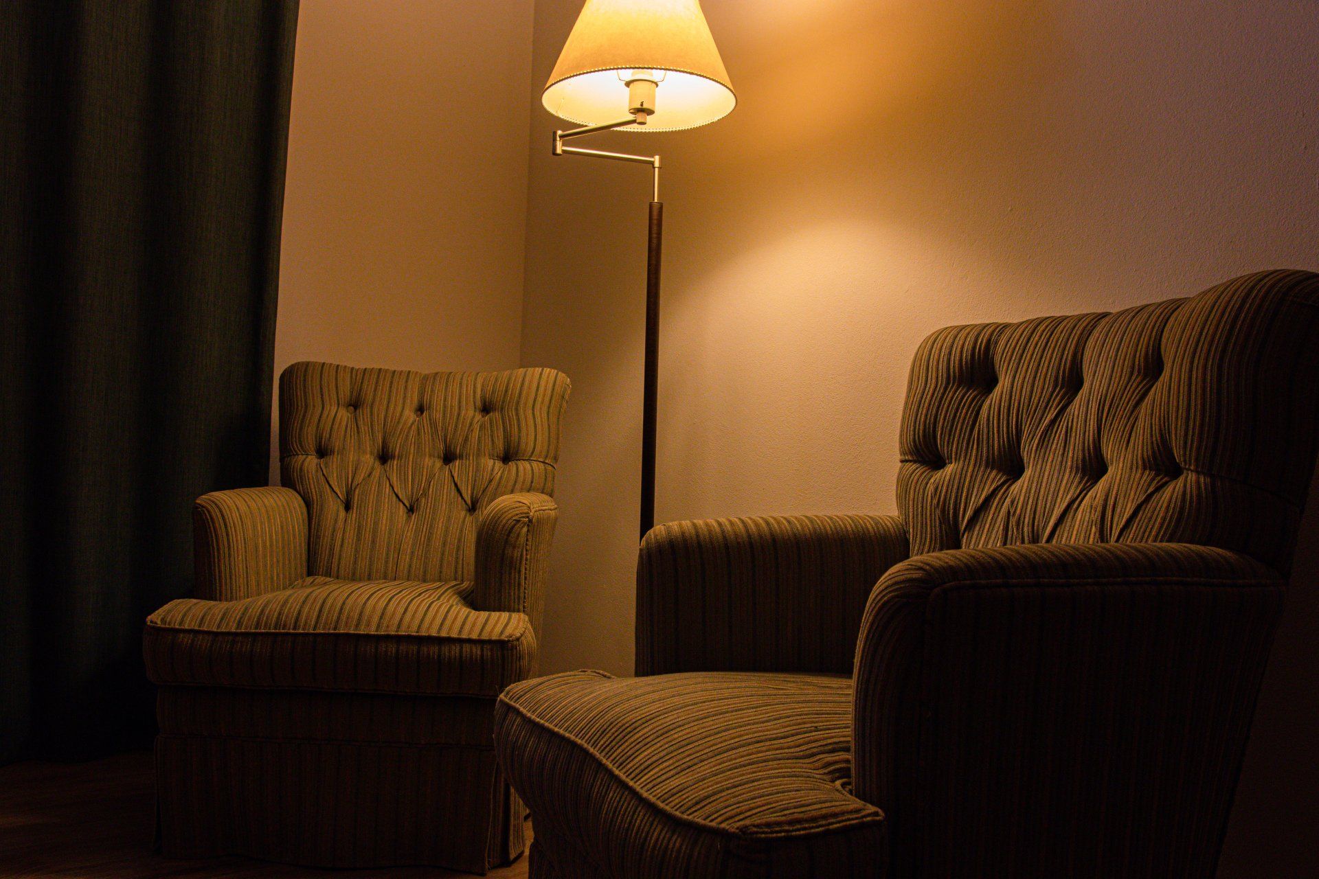 Un salón con dos sillas y una lámpara.