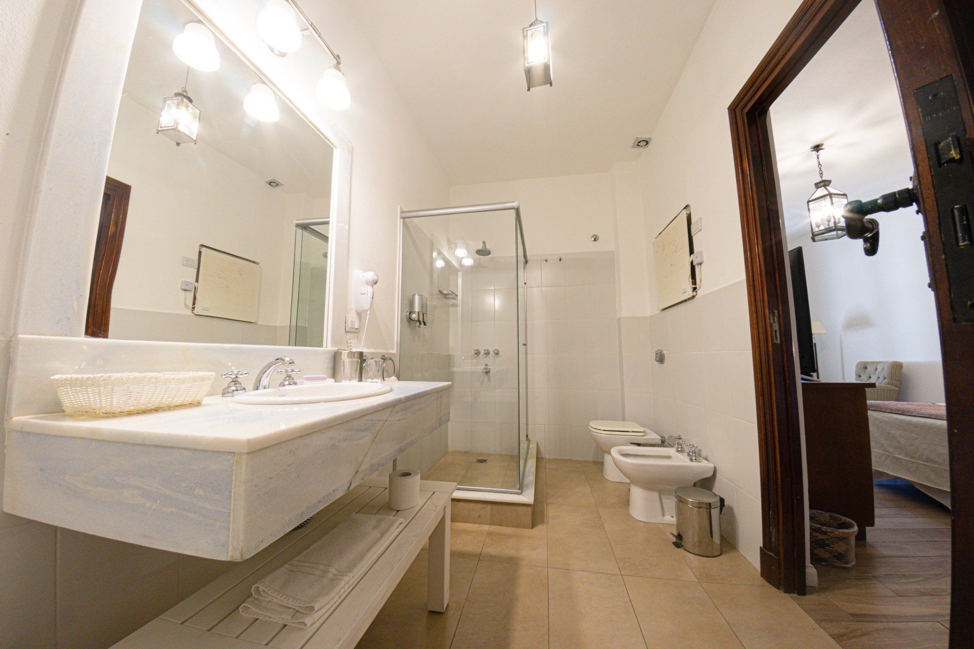 Un baño con dos lavabos, dos sanitarios y una cabina de ducha.