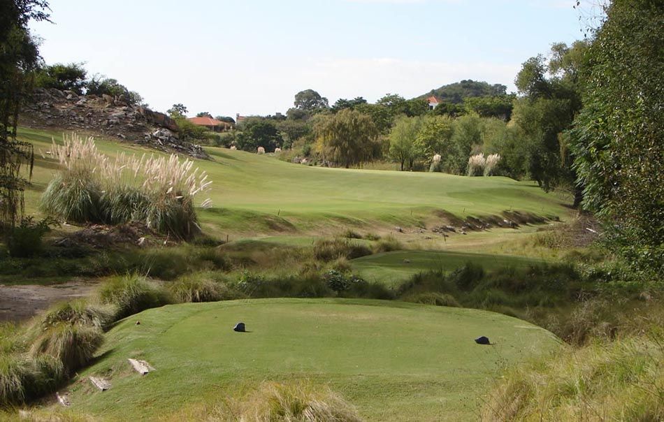 Un campo de golf con mucho césped y árboles.