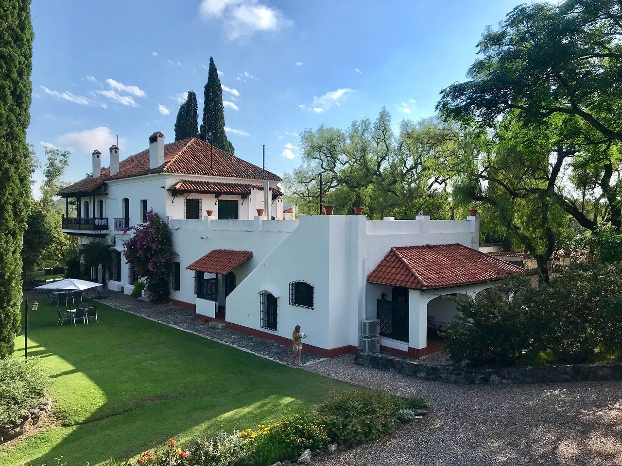 Una gran casa blanca con techo de tejas rojas.