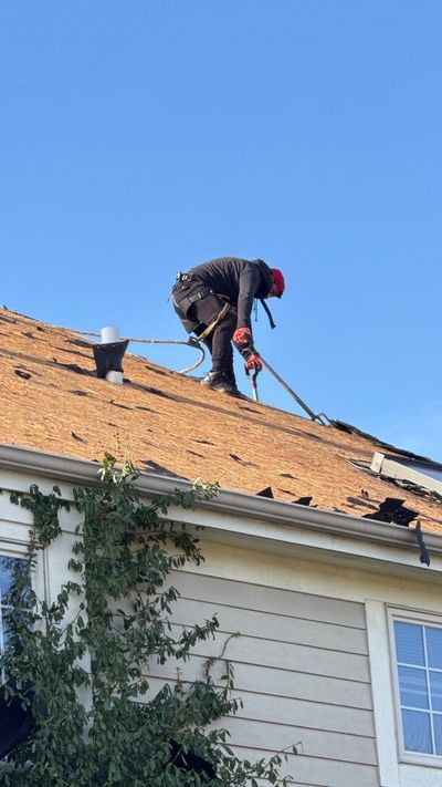 Logo for Just In Time Roofing & Exteriors: a red clock face with house roof and chimney silhouettes in red and black.