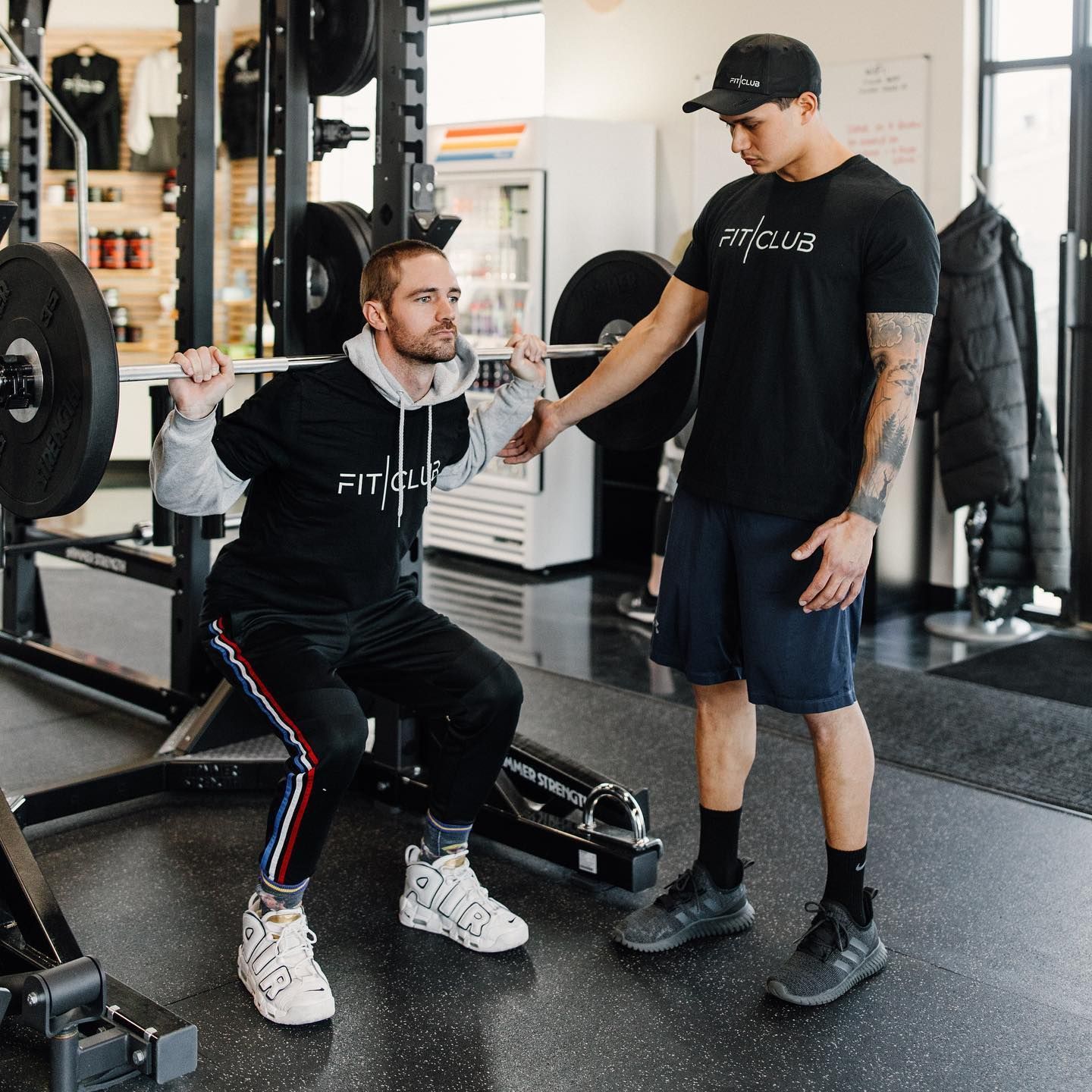 Personal training session at FitClub in Salem, Utah, with squats and weightlifting guidance.