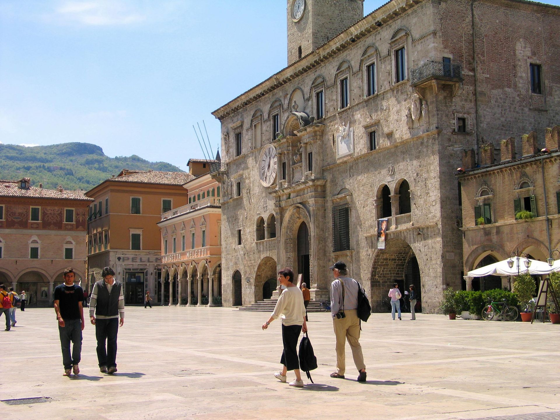 A group of people walking in front of a large building