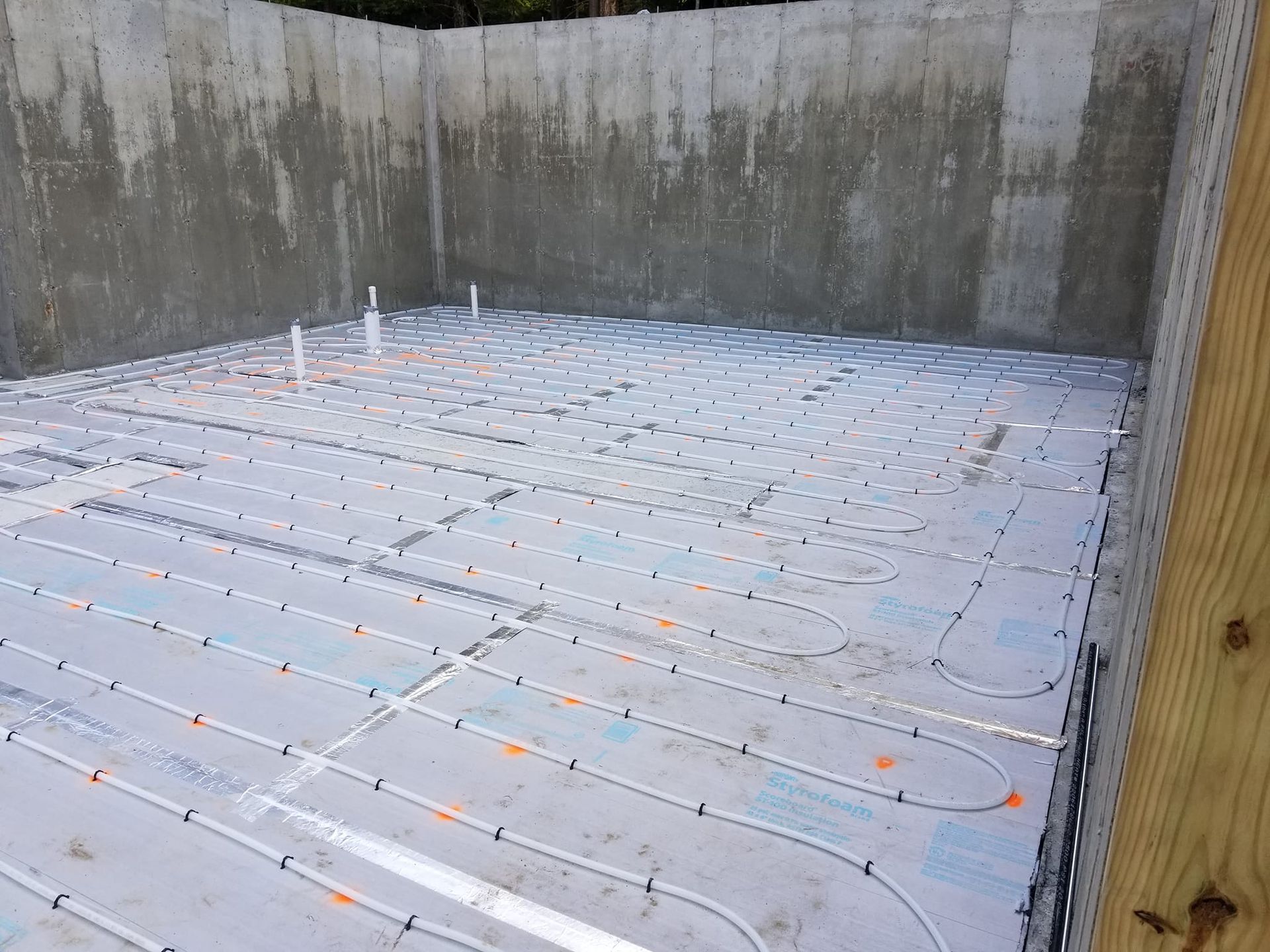 A basement under construction with a lot of pipes on the floor.