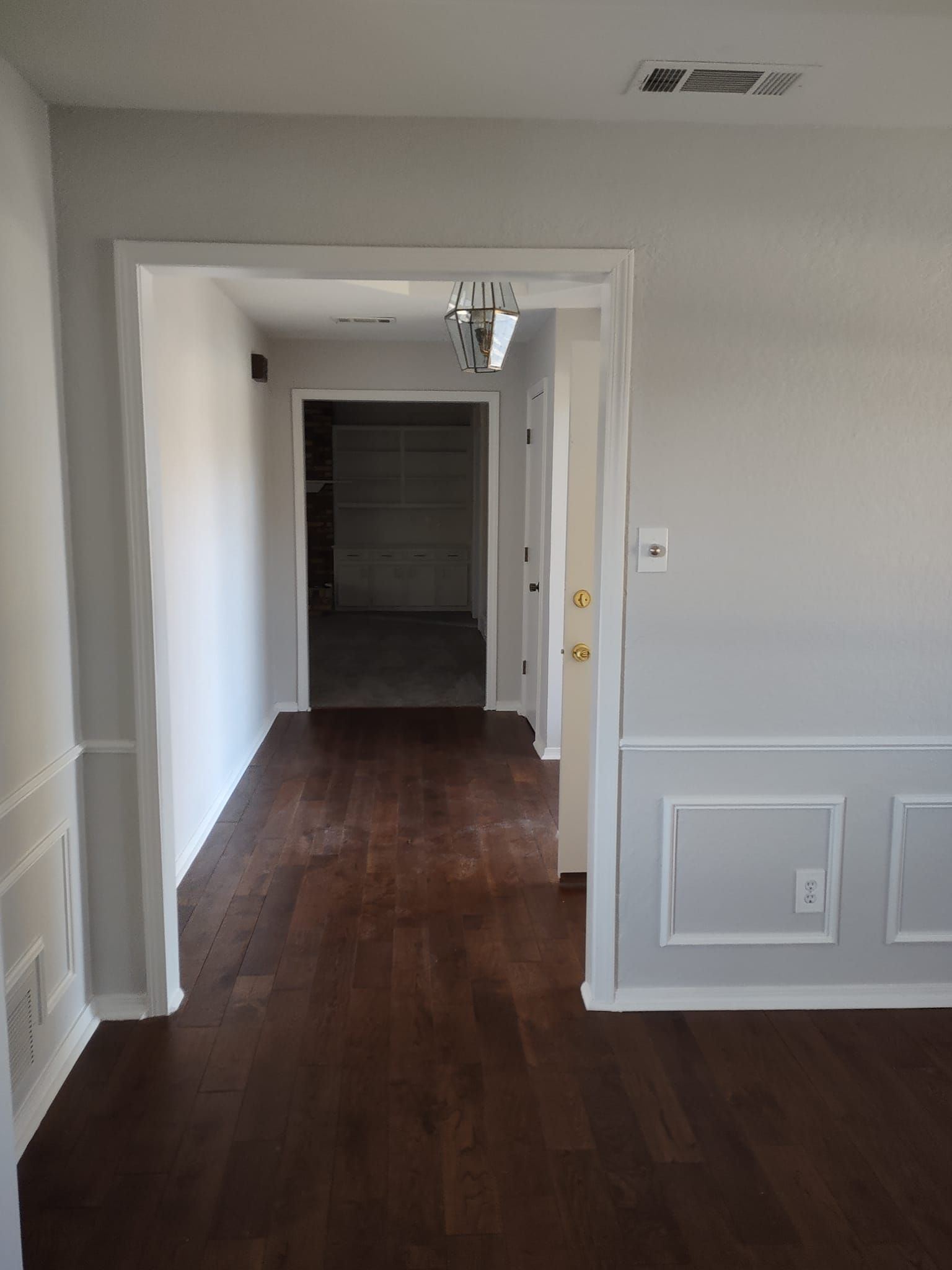 An empty room with hardwood floors and gray walls