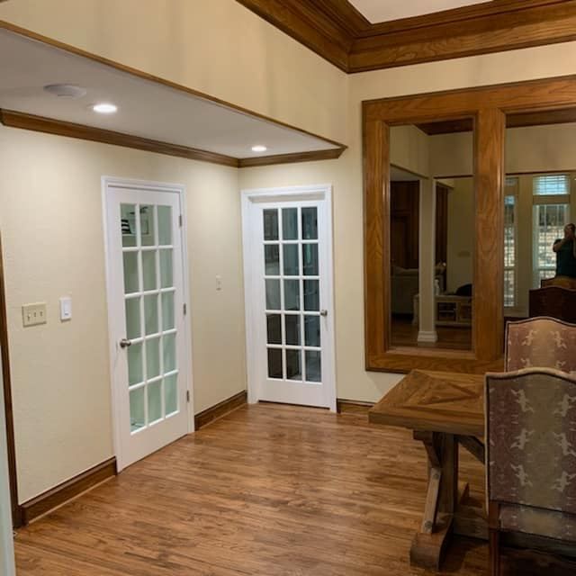 A dining room with a table and chairs and a mirror