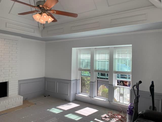 A living room with a ceiling fan and a fireplace