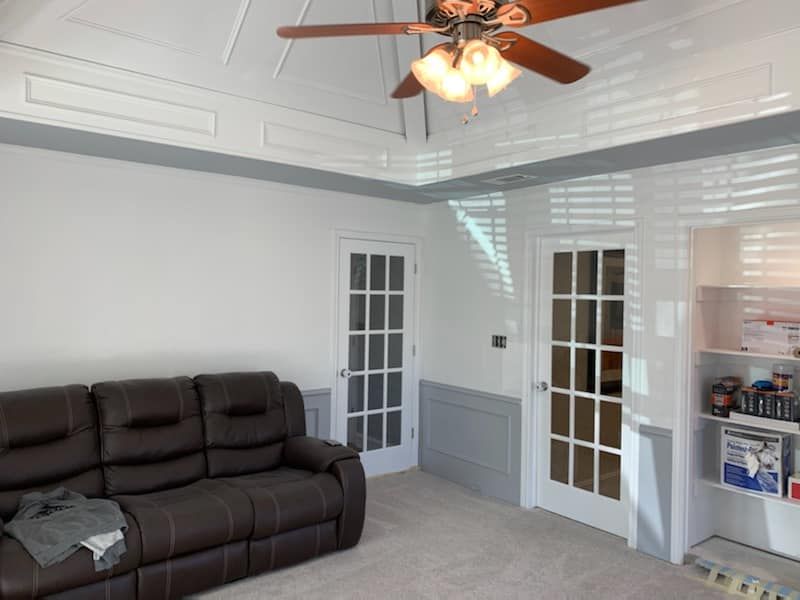 A living room with a brown couch and a ceiling fan