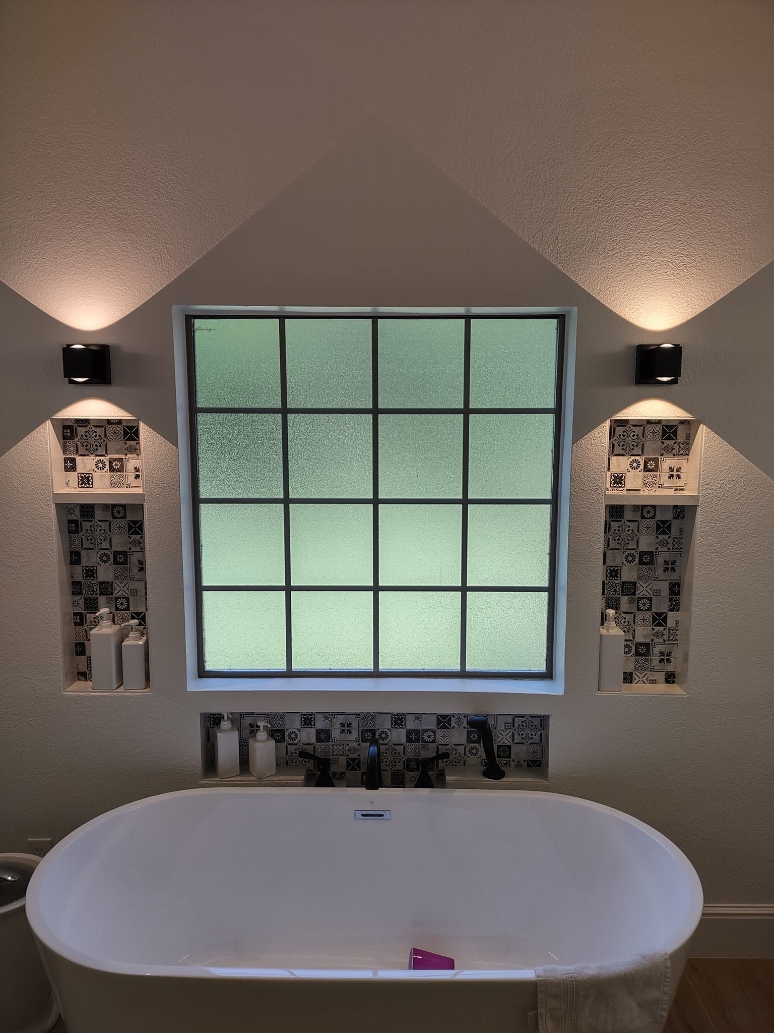 A bathroom with a bathtub and a window.