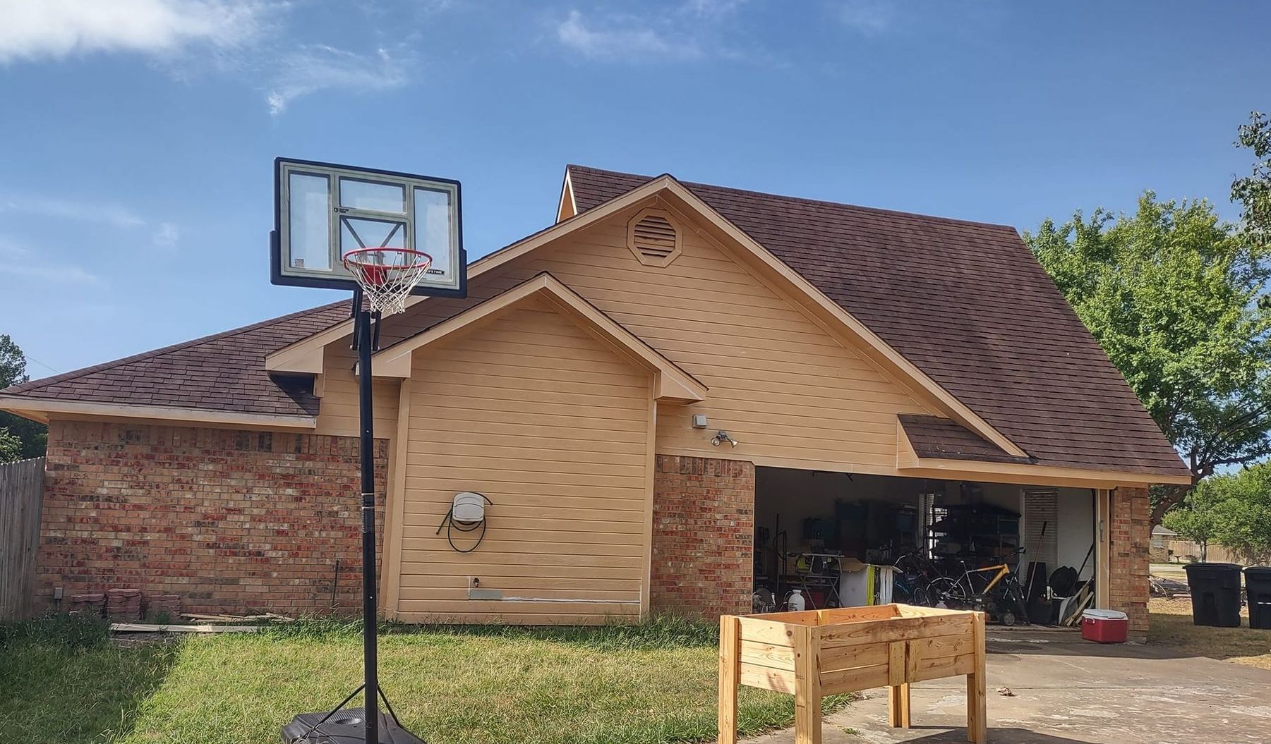 A basketball hoop is sitting in front of a brick house.