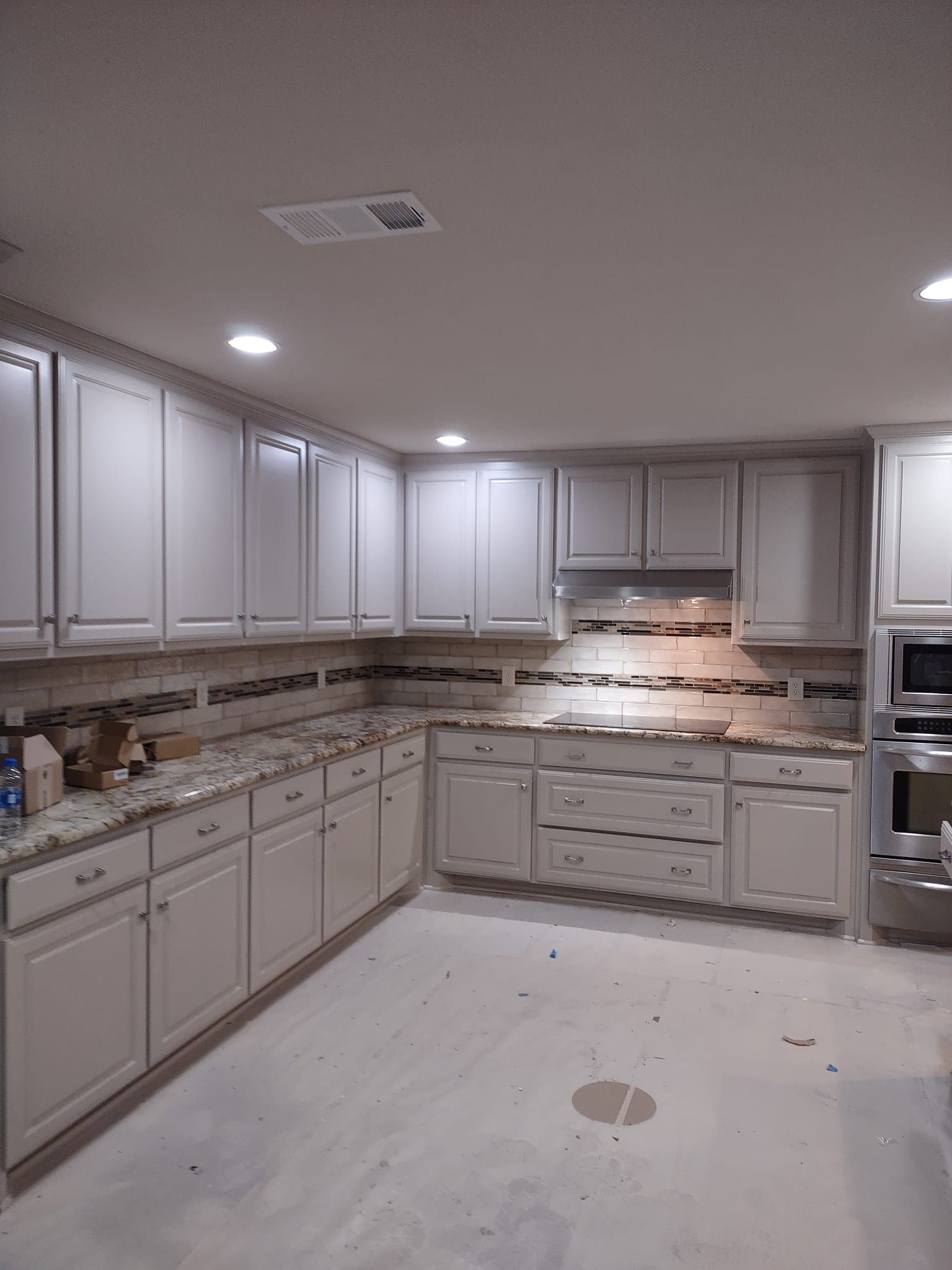 A kitchen with white cabinets and granite counter tops