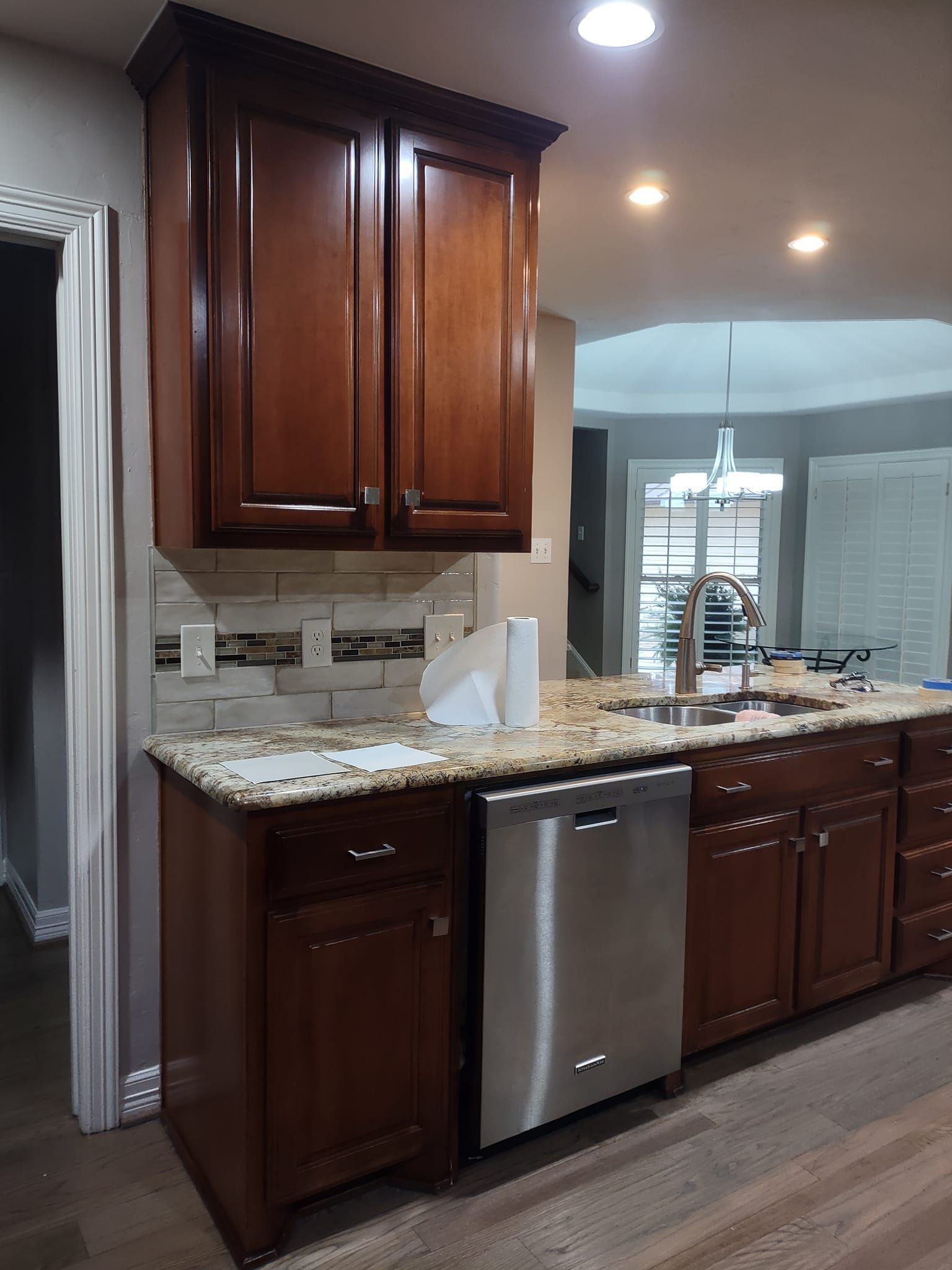 A kitchen with wooden cabinets and a stainless steel dishwasher