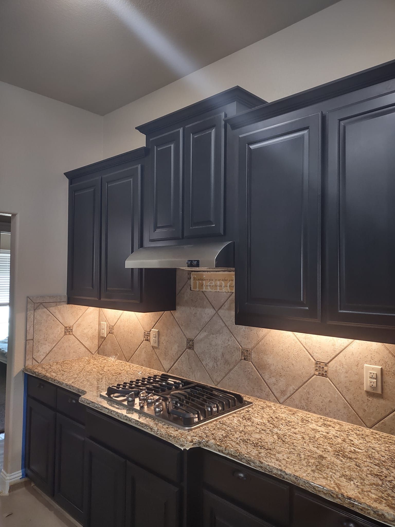 A kitchen with black cabinets and granite counter tops
