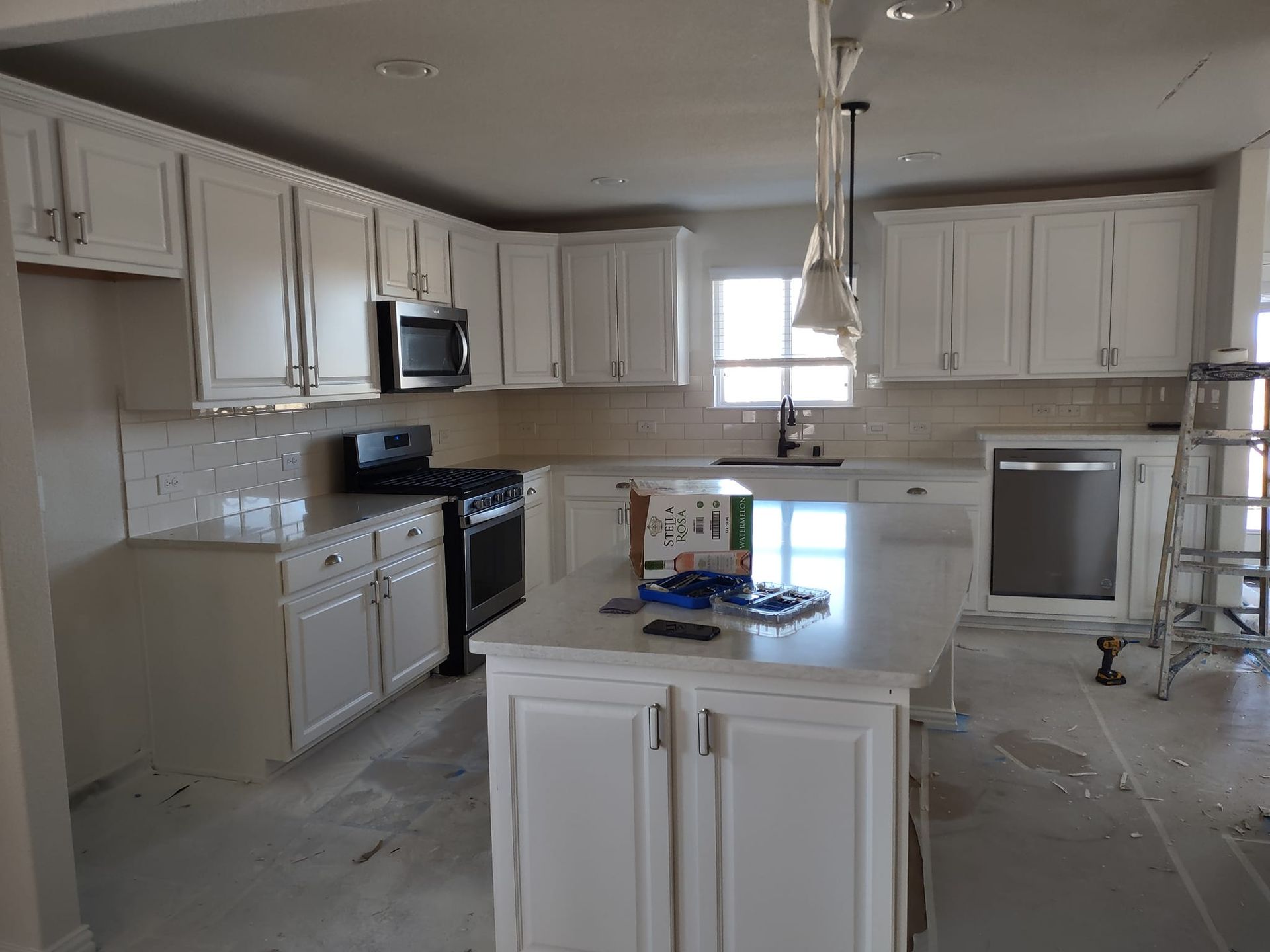 A kitchen with white cabinets and stainless steel appliances