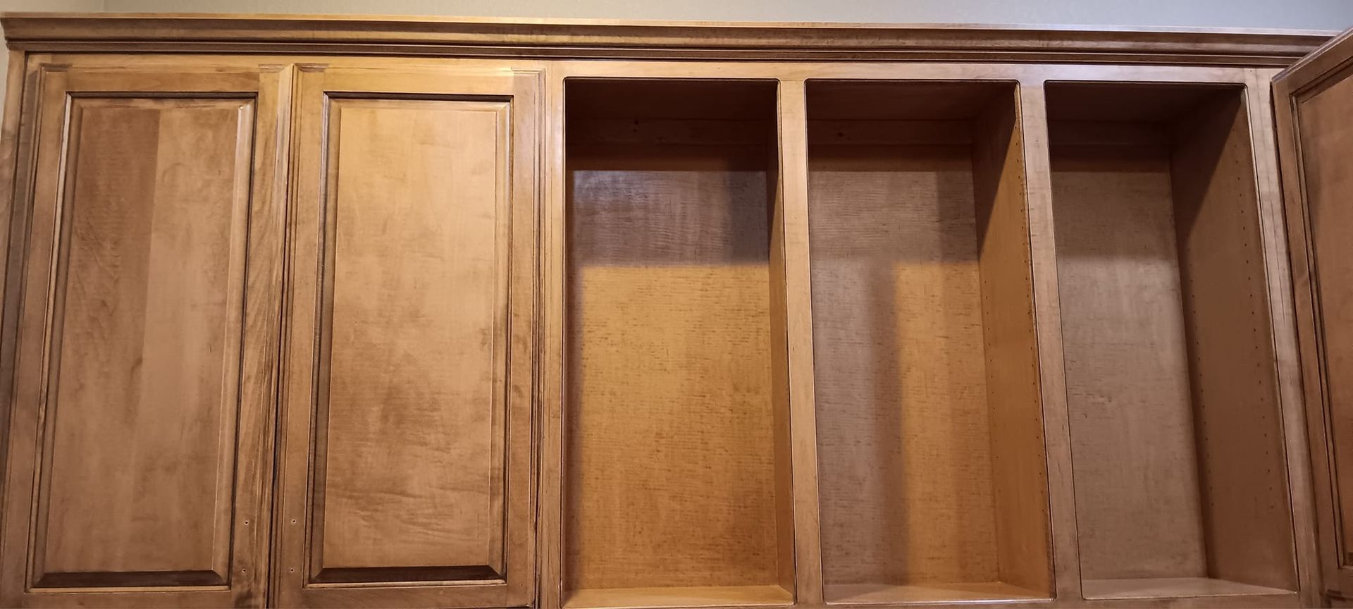 A close up of a wooden cabinet with empty shelves.