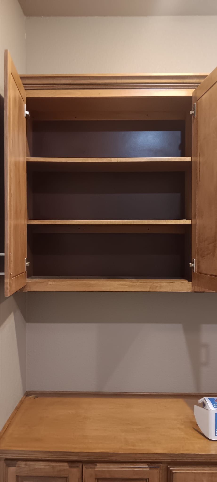 An empty cabinet with the door open in a kitchen.