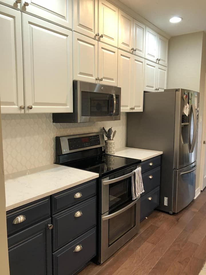 A kitchen with stainless steel appliances and blue cabinets