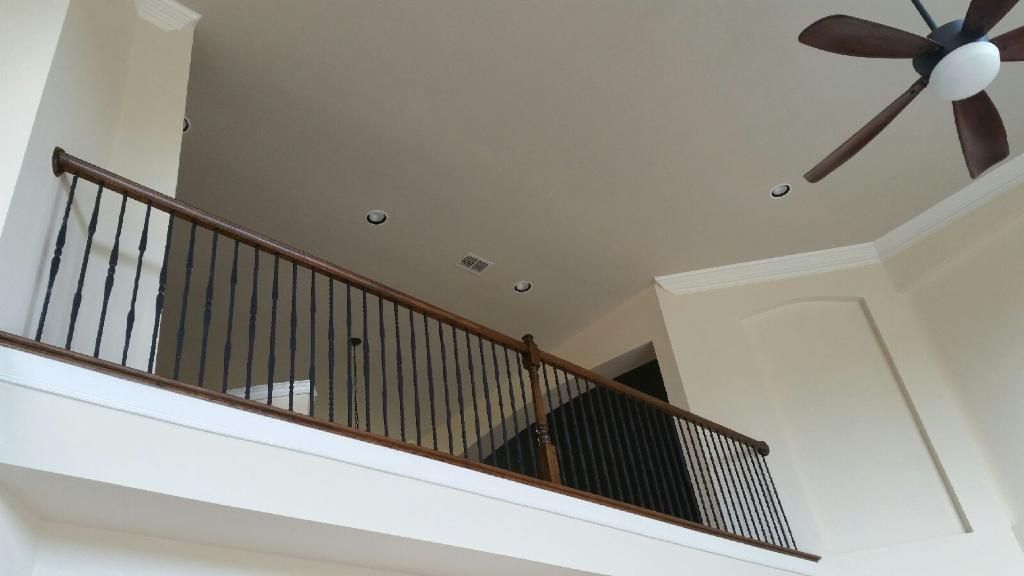 A balcony with a railing and a ceiling fan