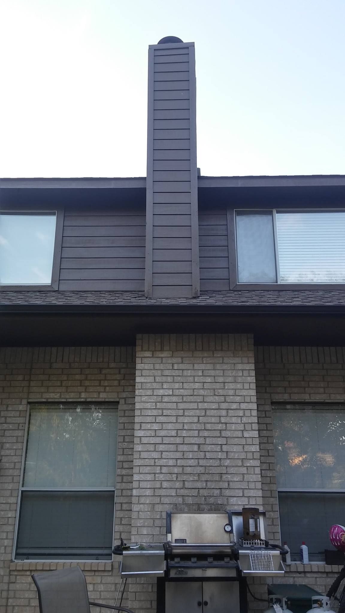 A brick house with a large chimney on the side of it.