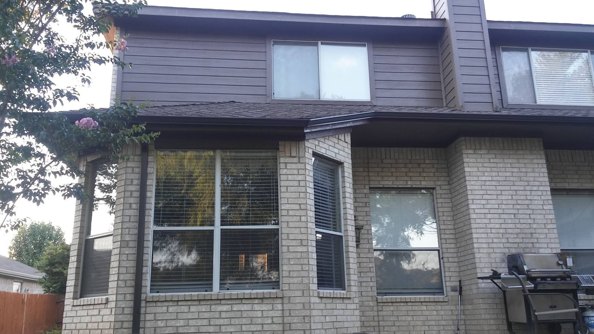 The back of a brick house with a broken roof