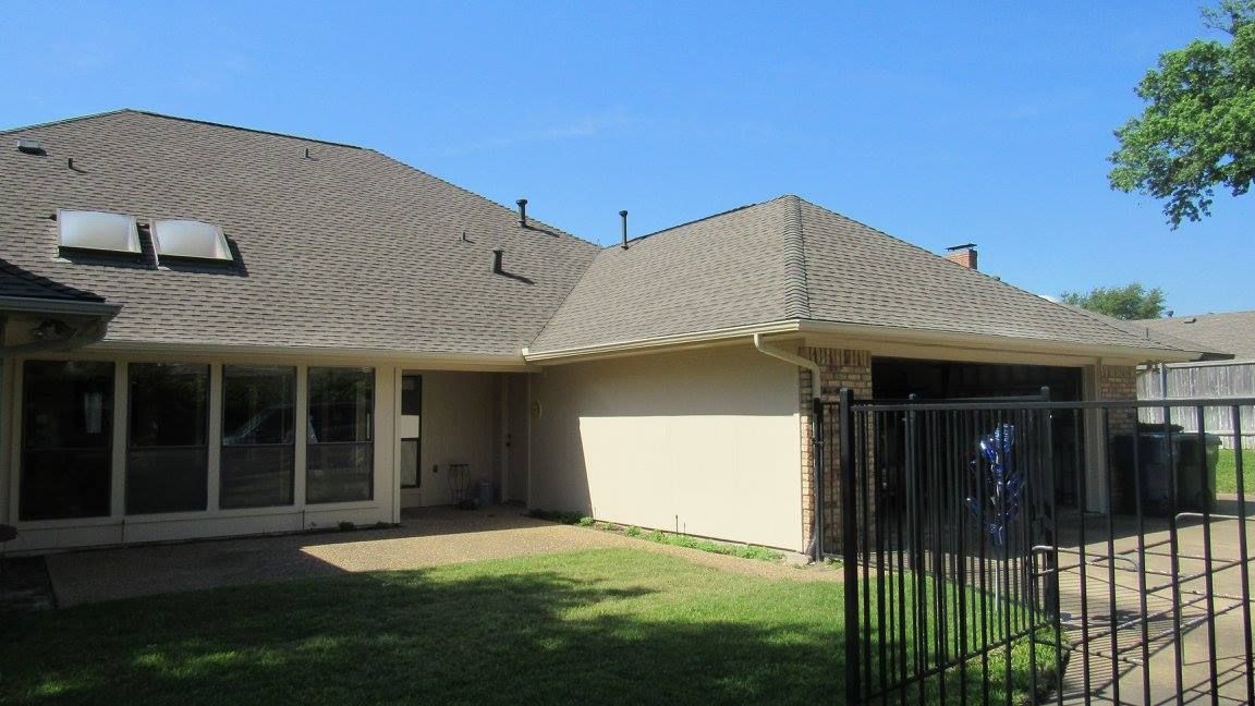 The back of a house with a fence and a garage.