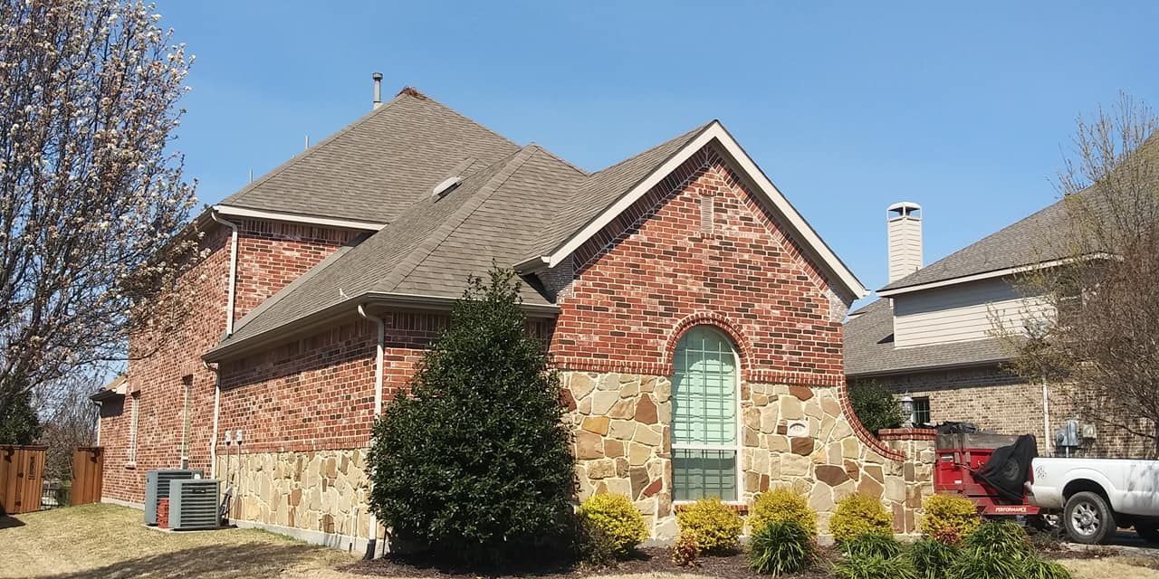 A brick house with a car parked in front of it