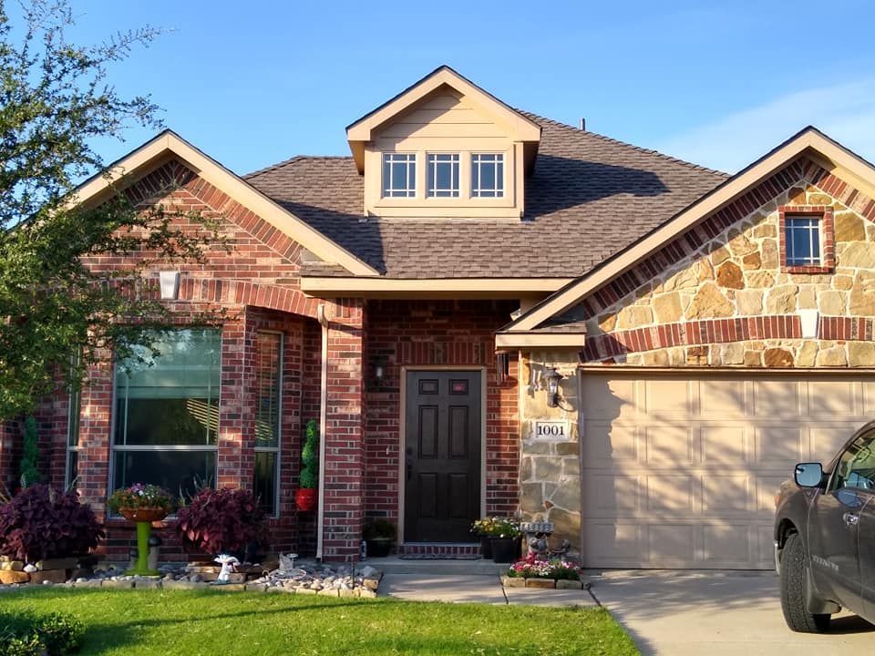 A brick house with a car parked in front of it