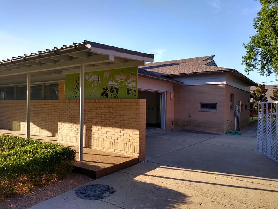 A brick building with a green roof and a walkway leading to it.