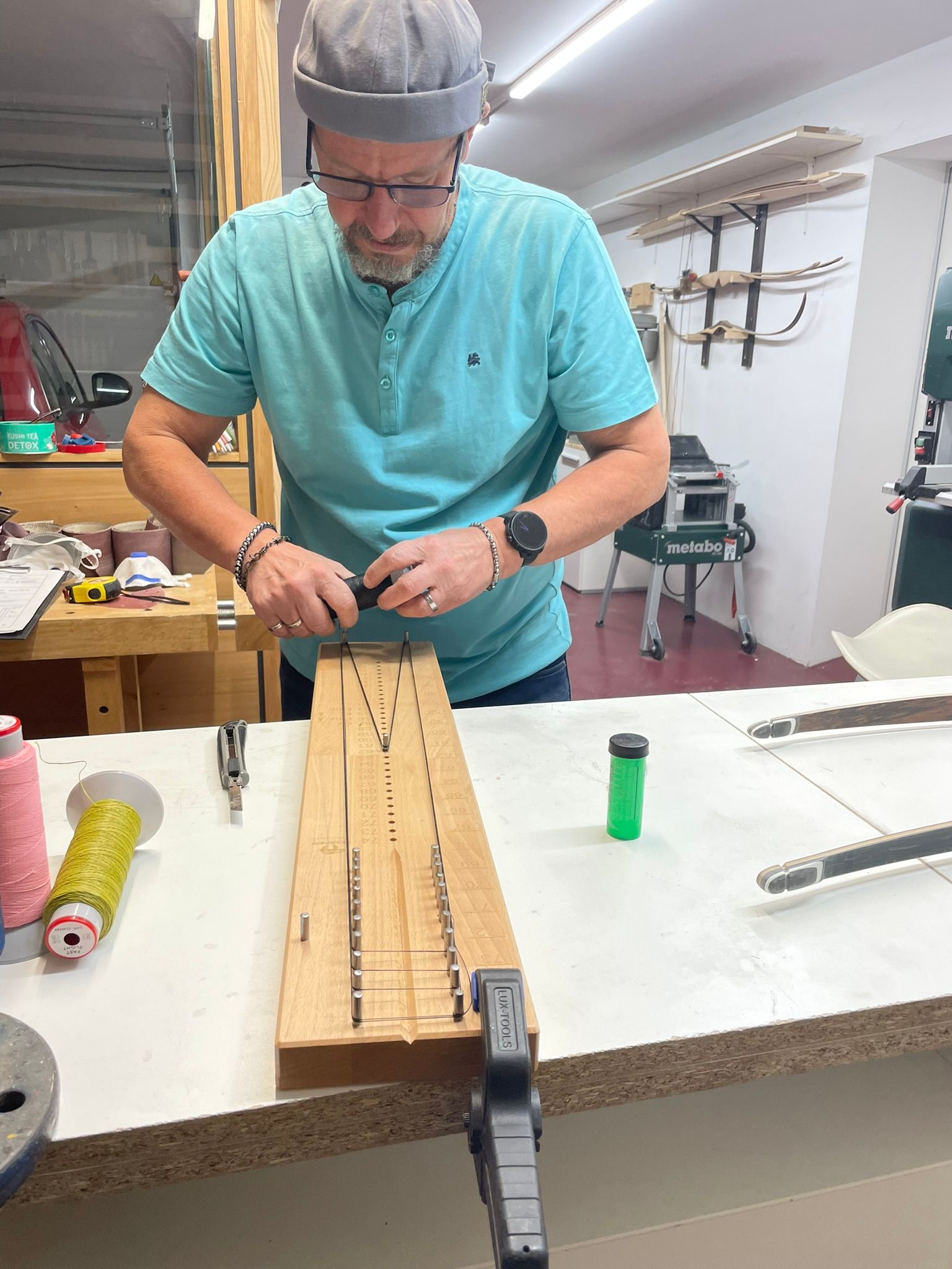 Ein Mann im blauen Hemd arbeitet an einem Stück Holz