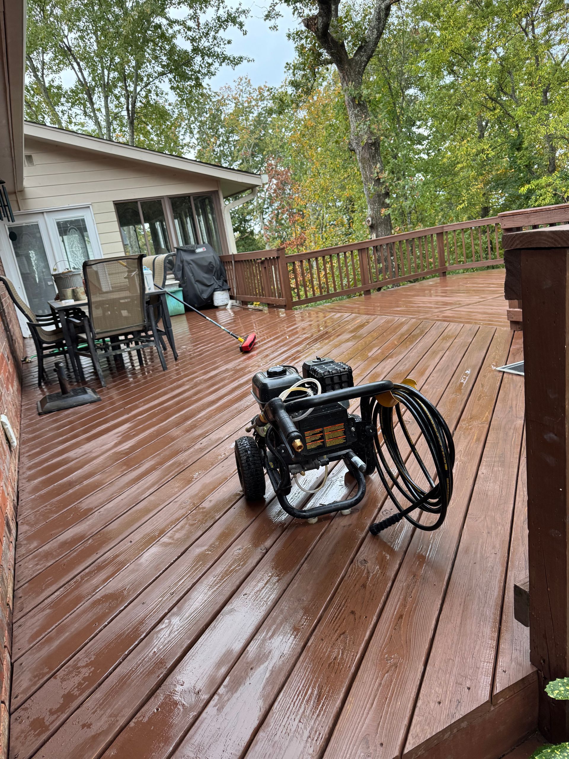 A pressure washer is sitting on a wooden deck.