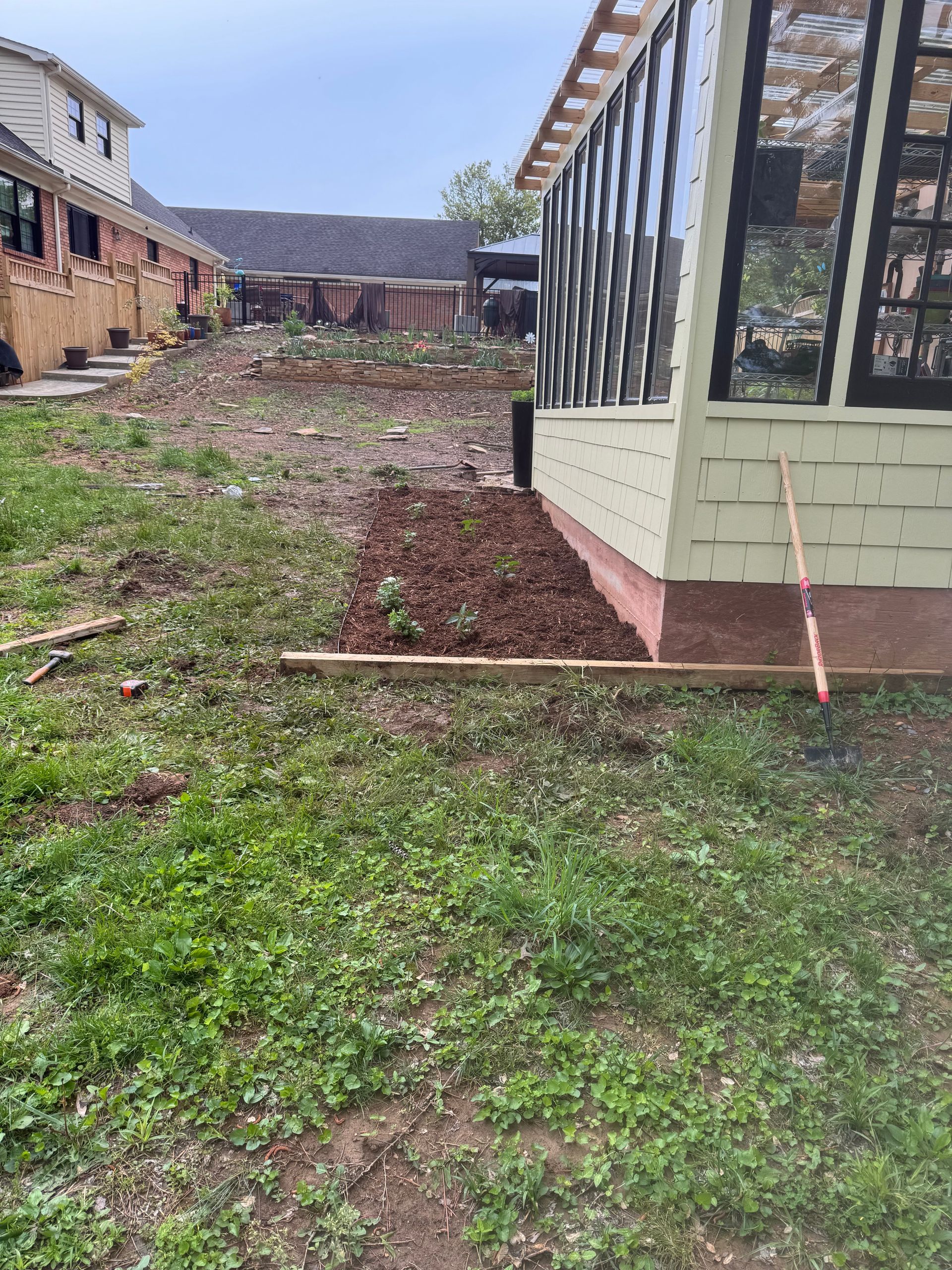 A greenhouse is being built in the backyard of a house.