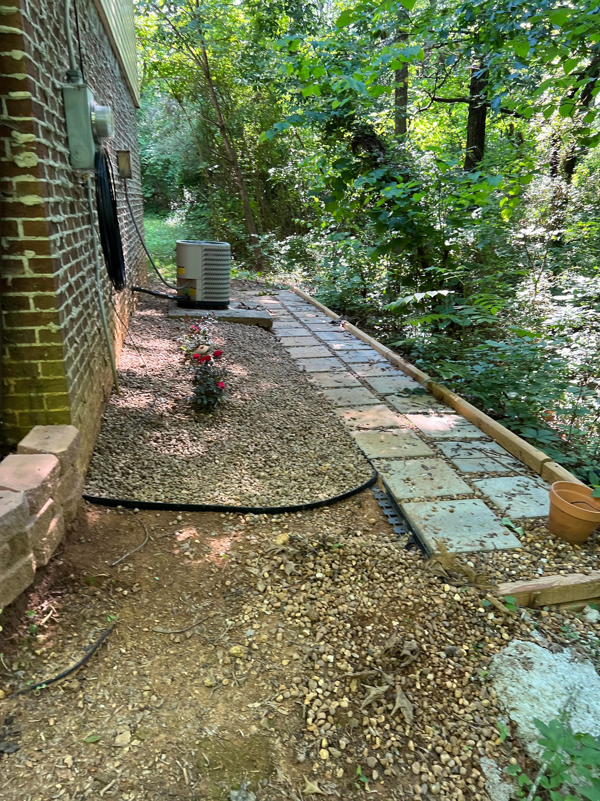 A sidewalk is being built in front of a brick house.