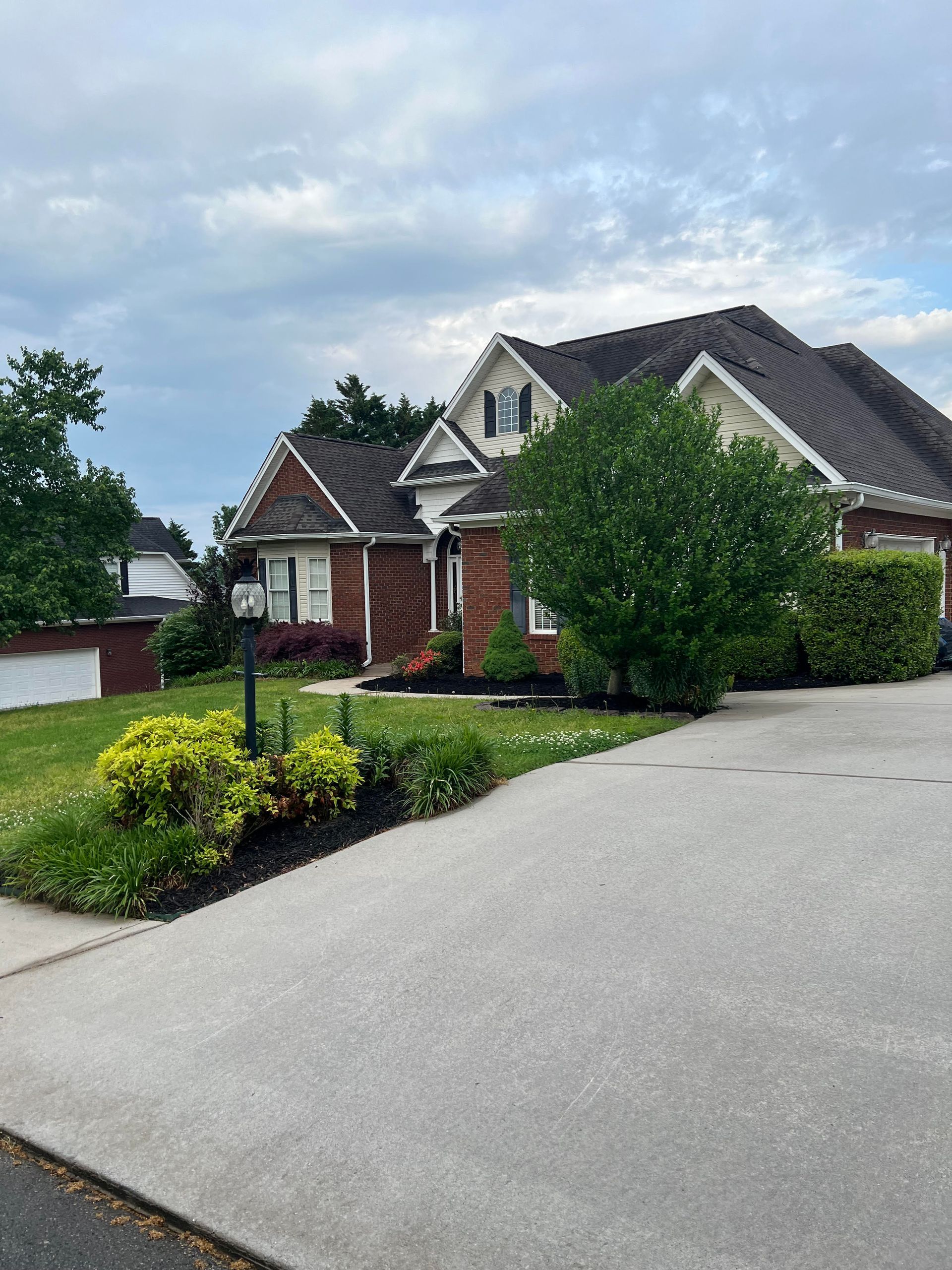 A large brick house with a driveway leading to it
