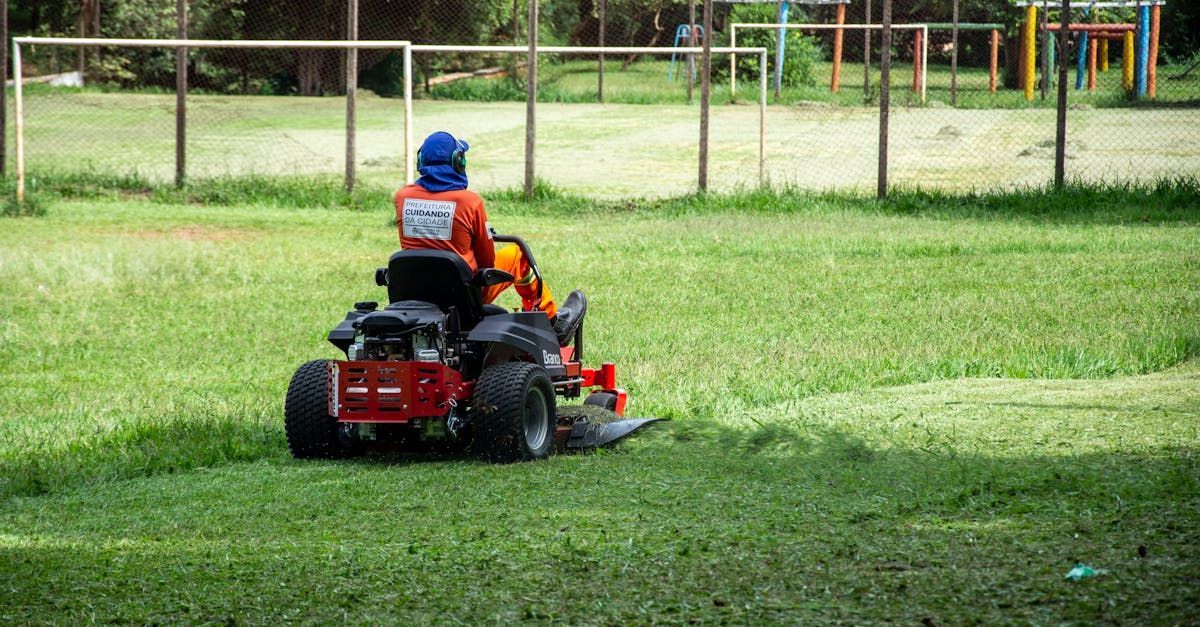 A man is riding a lawn mower on a soccer field.