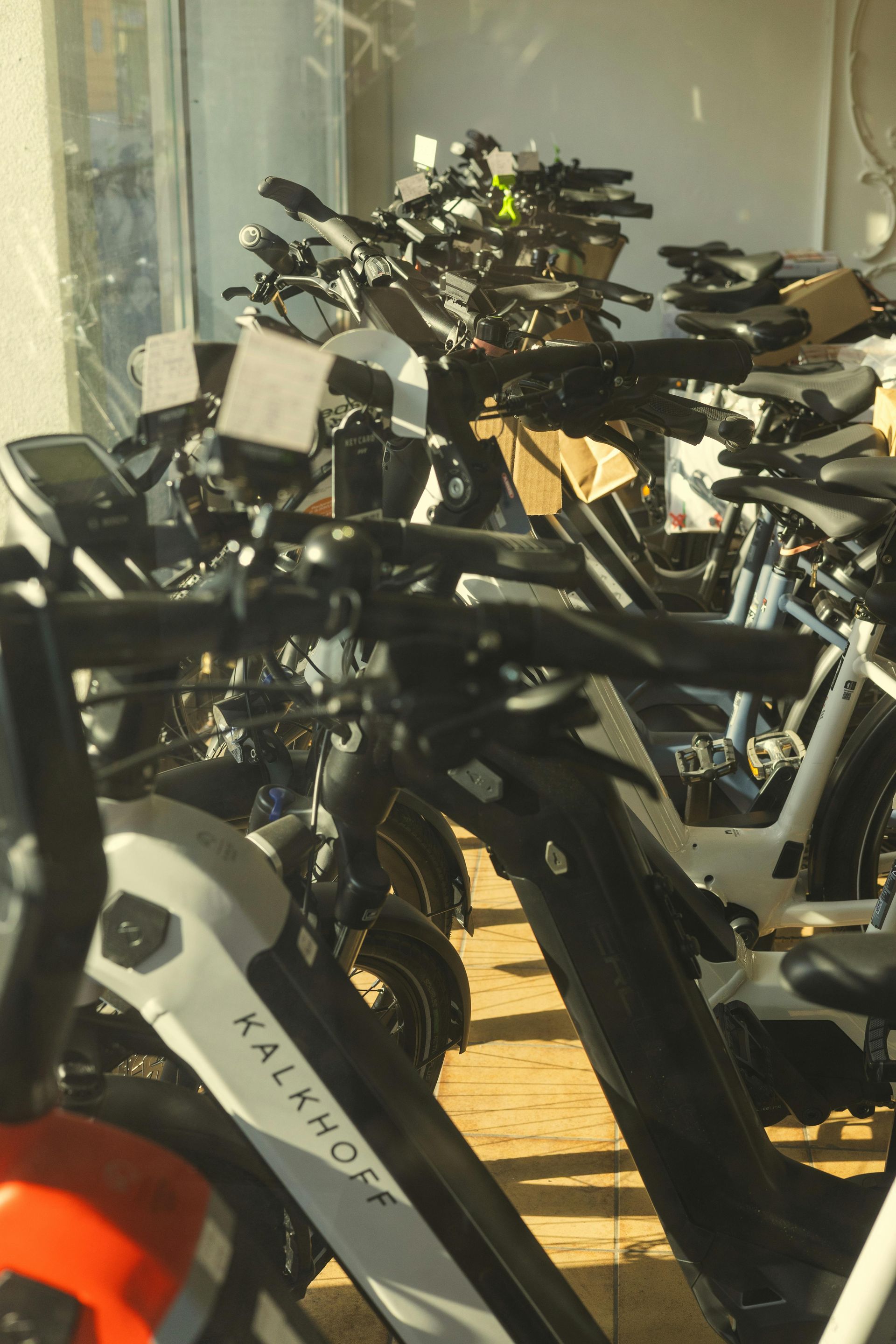 A row of electric bikes are lined up in a showroom.