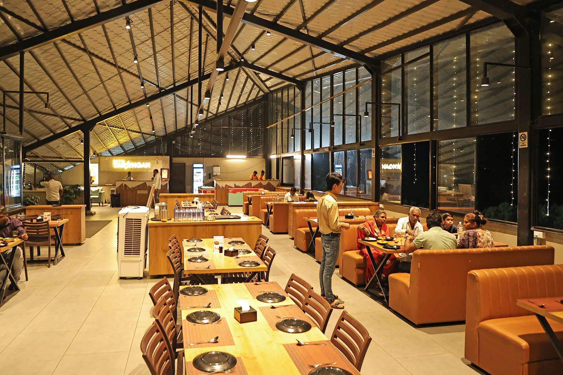 A group of people are sitting at tables in a restaurant.