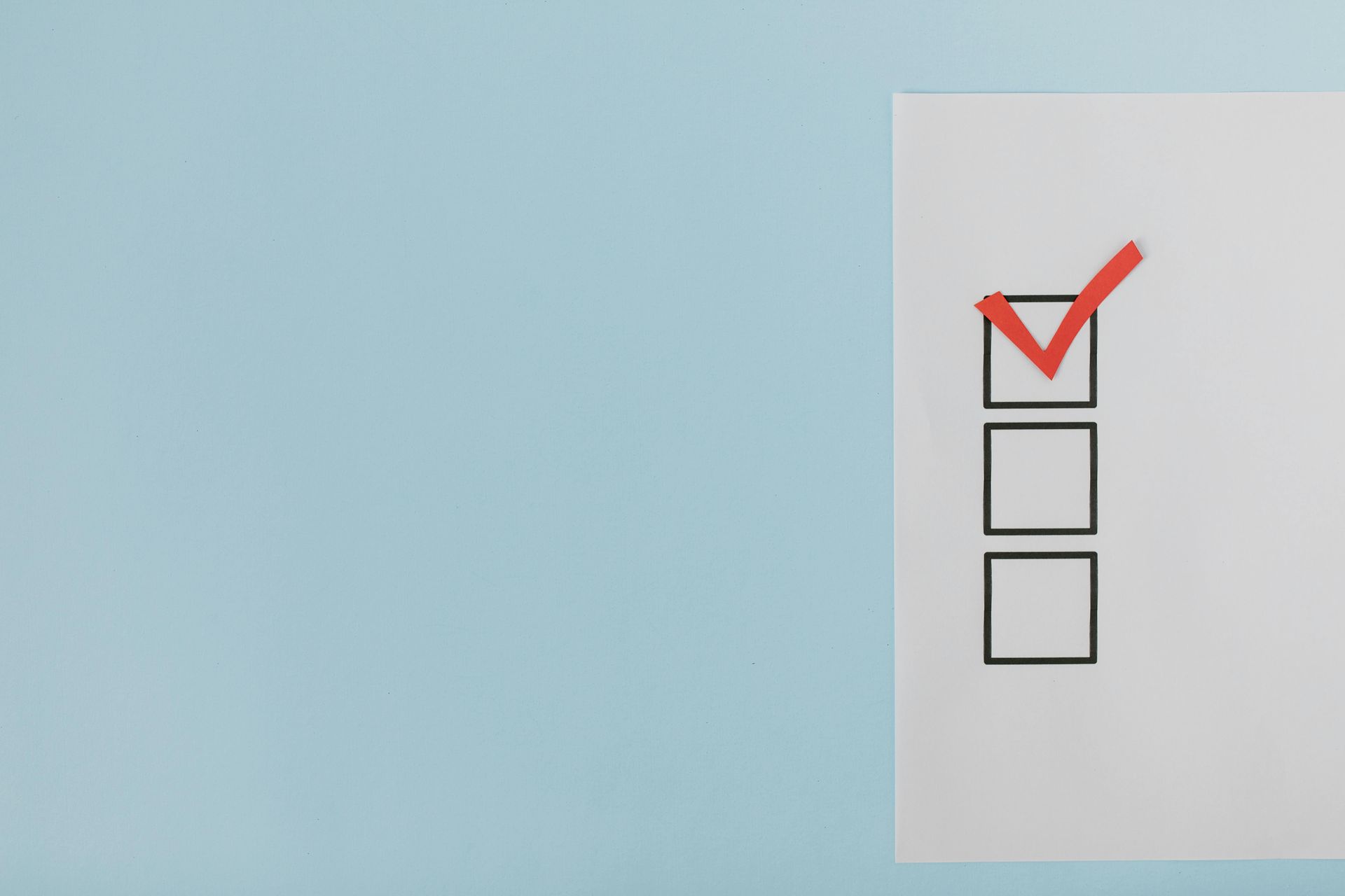 A checklist with a red check mark on a blue background.