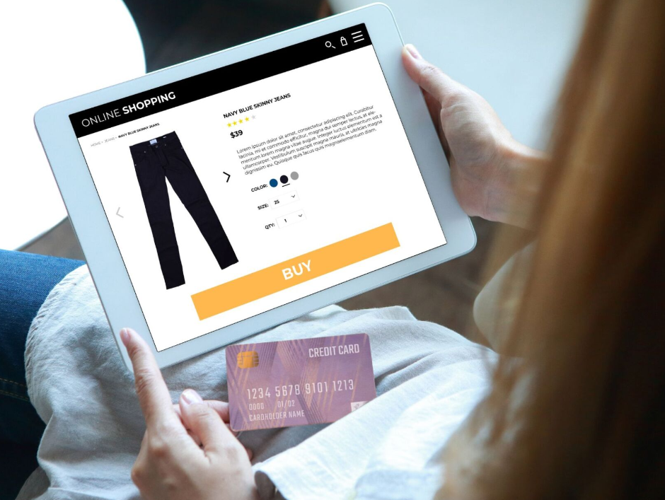 A woman is holding a credit card and a tablet.