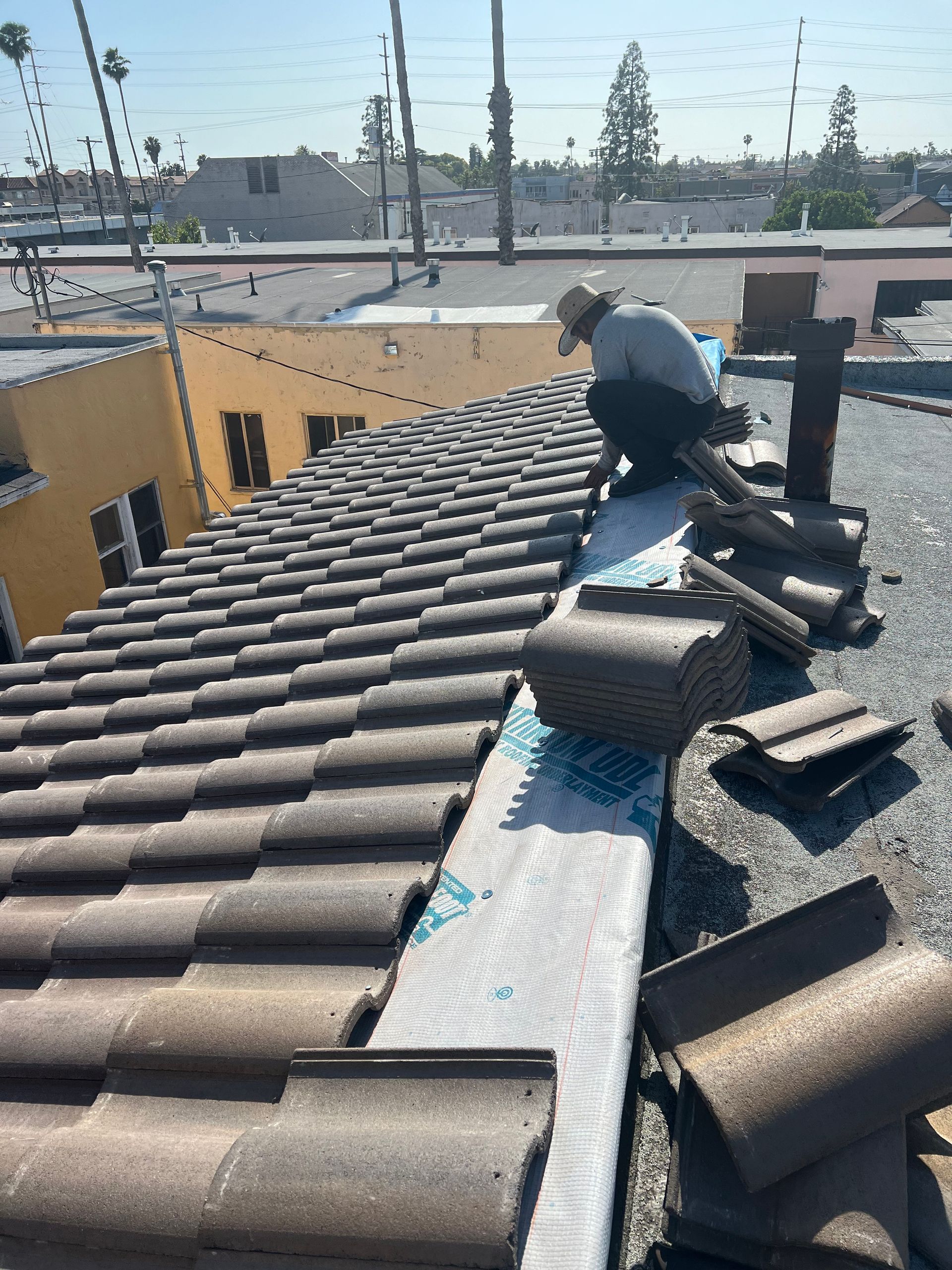Handyman using nail gun to install shingle to repair roof