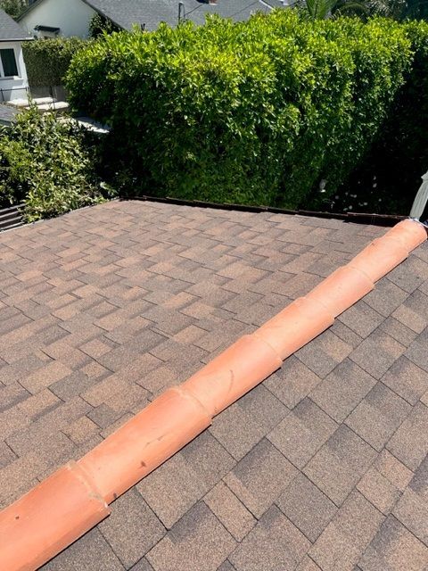 Two men are working on the roof of a house.