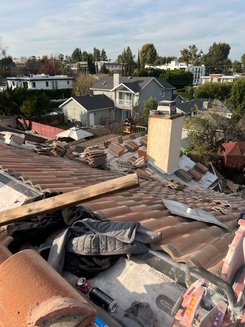 A roof with a lot of tools on it and a chimney in the background