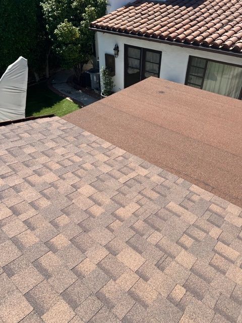 A man is working on the roof of a house.