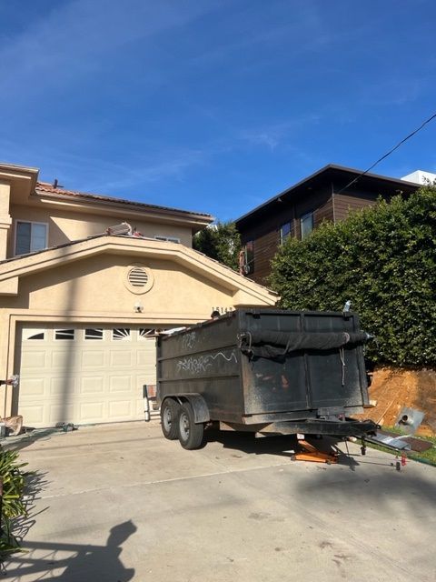 A dumpster is parked in front of a house
