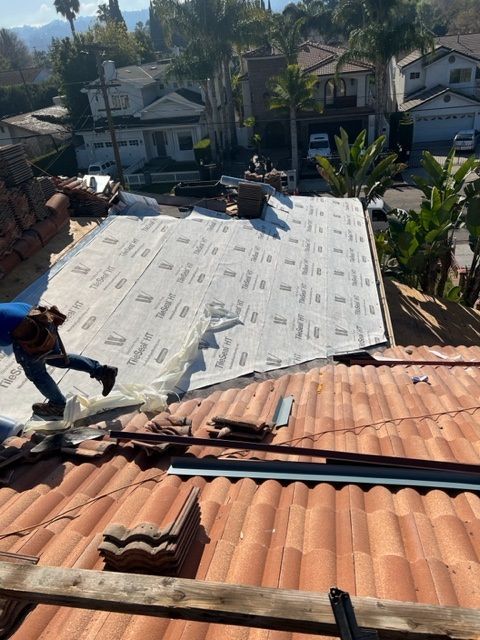 A man is working on the roof of a house