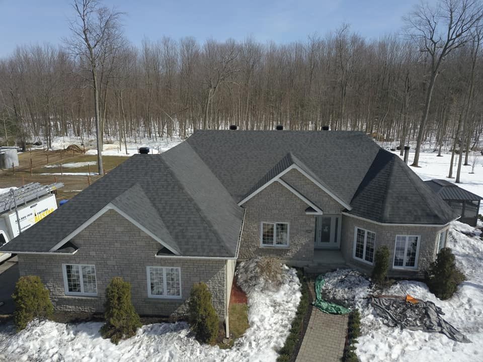 Une vue aérienne d'une maison avec un toit recouvert de neige.