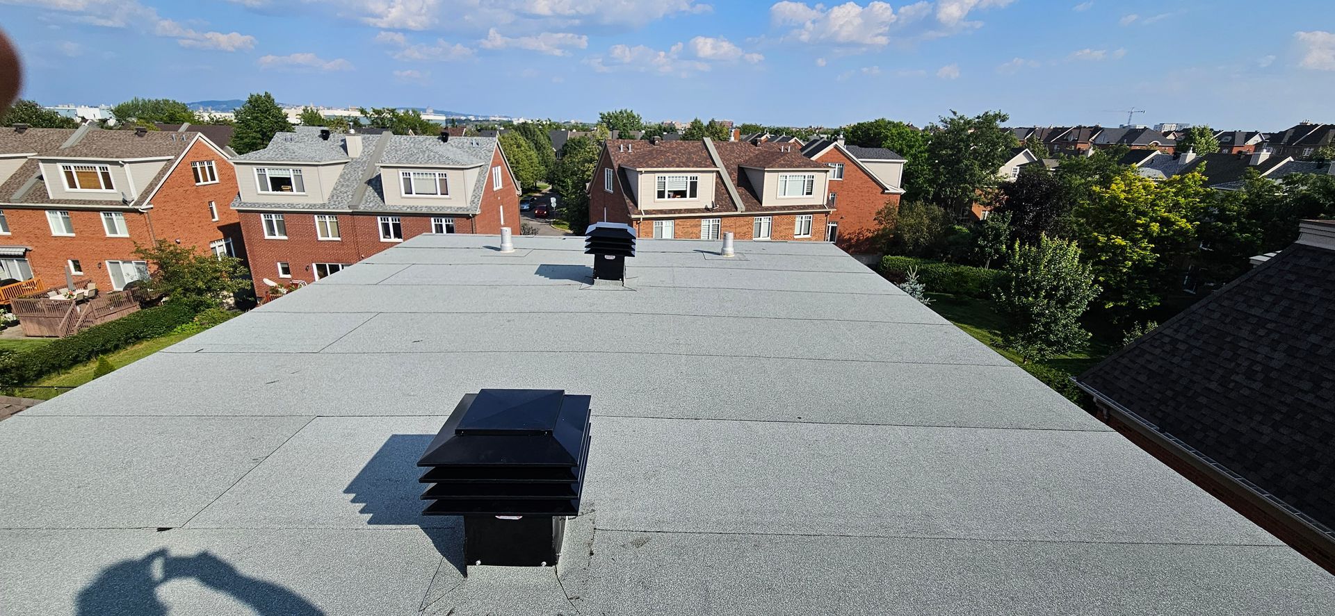 Un toit avec une cheminée dessus et une vue sur une ville.