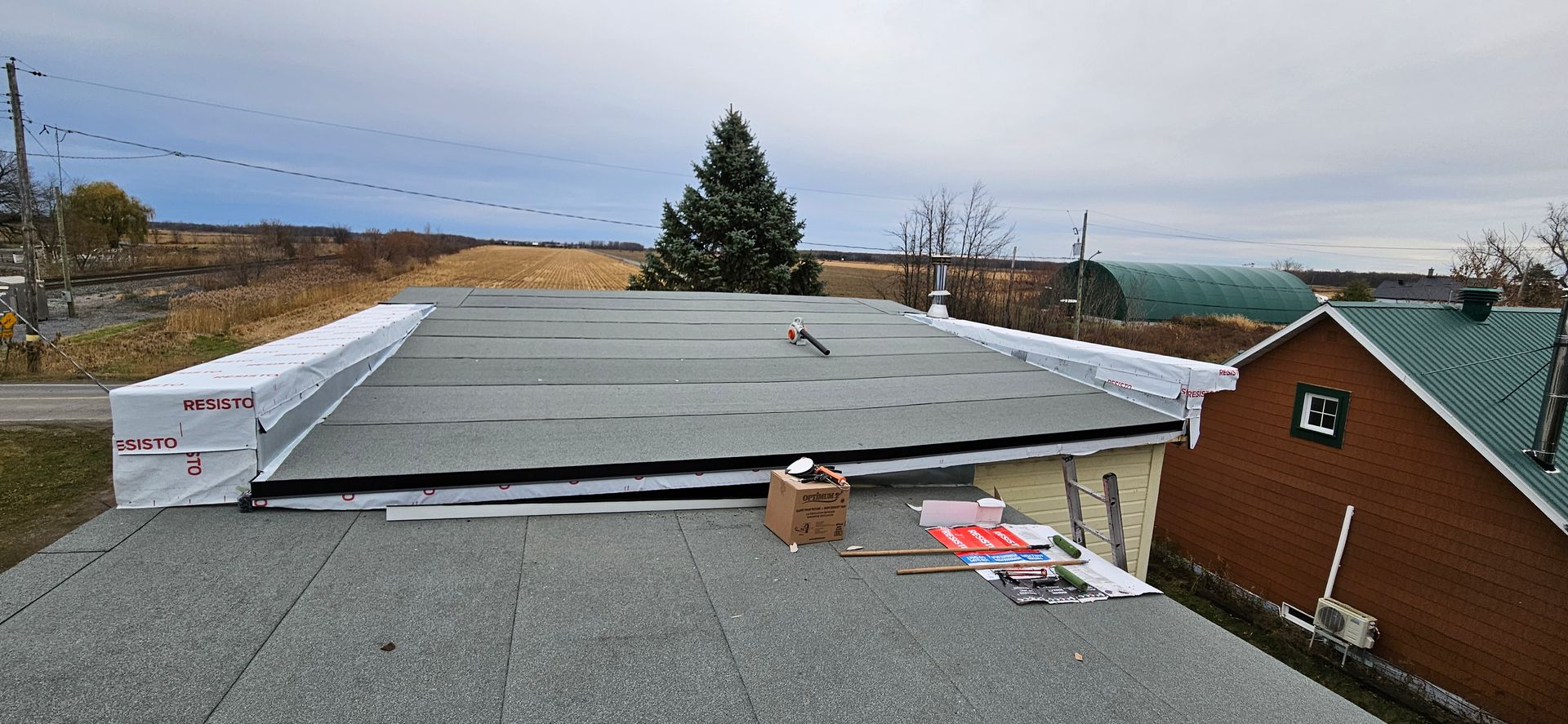 Un toit avec une boîte dessus et une maison en arrière-plan.